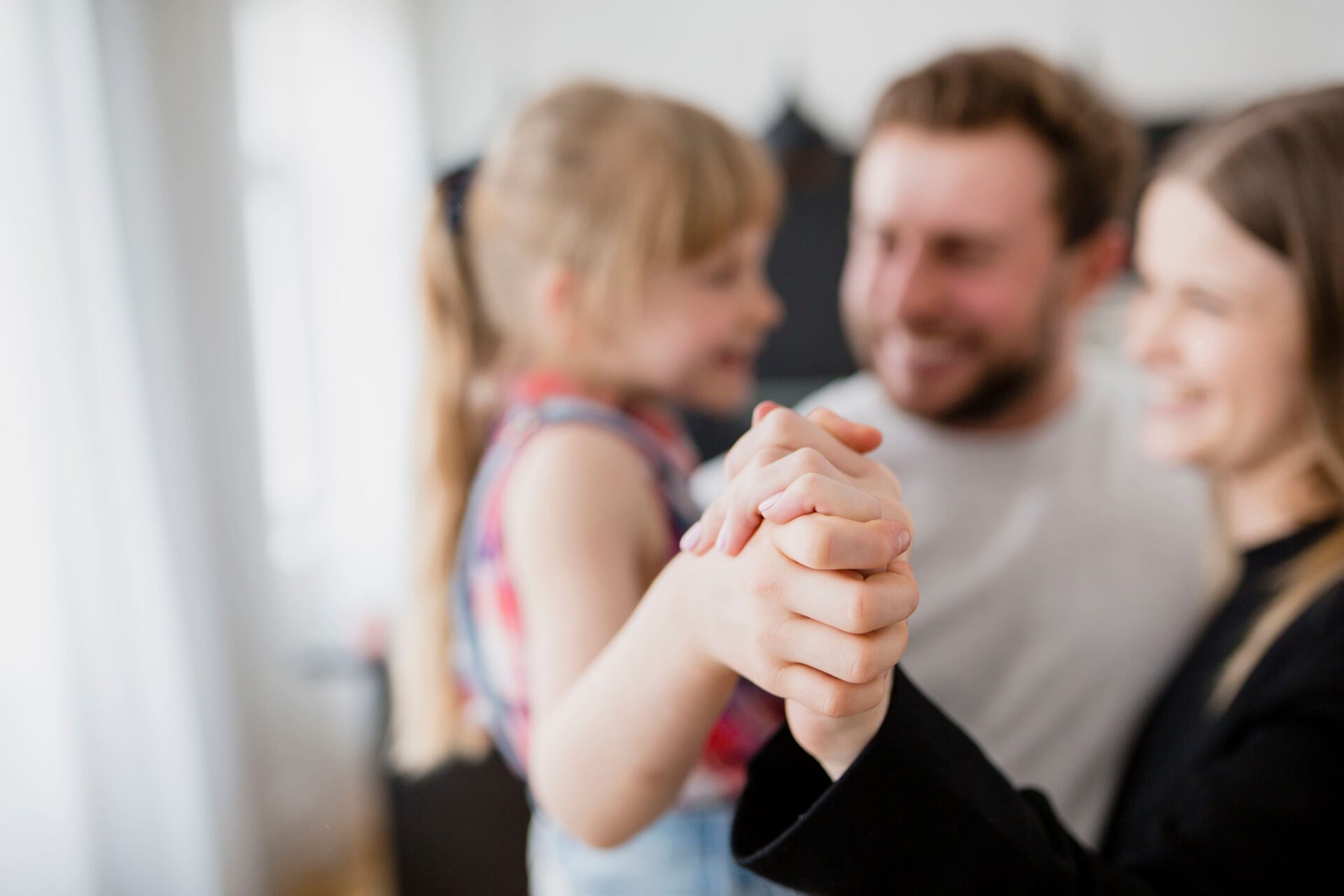 A man and woman hold hands with a little girl